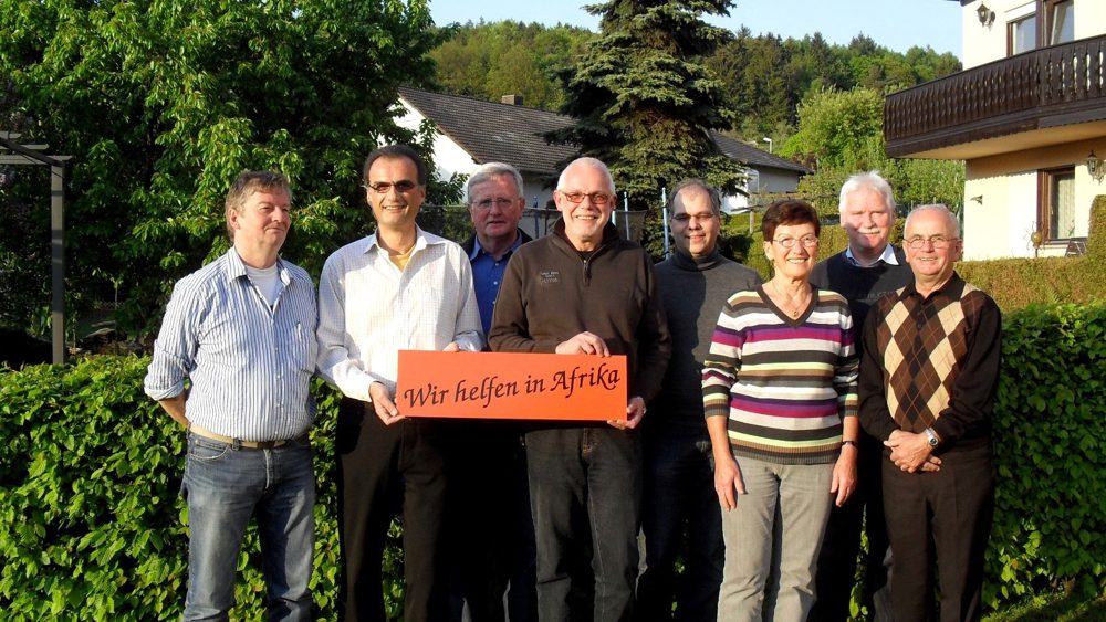 Gründungsmitglieder und Unterstützer mit dem Schild „Wir helfen in Afrika“